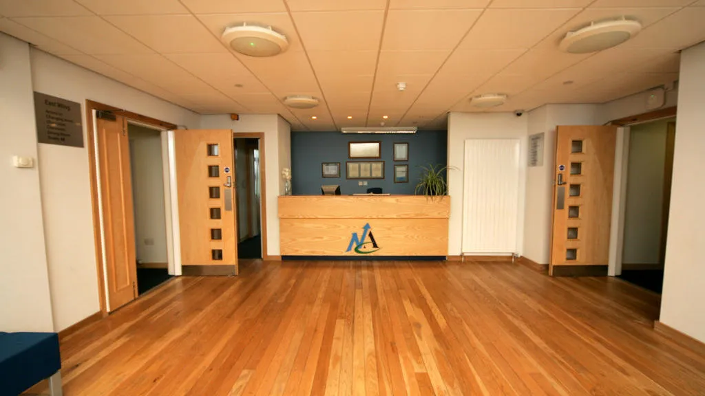 Reception with wooden floor and desk with North ayrshire council logo.